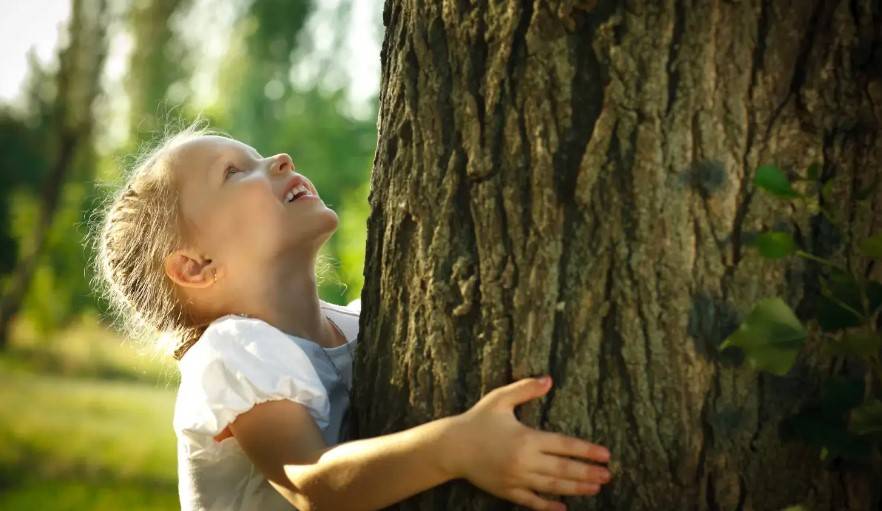 Kind das Baum umarmt